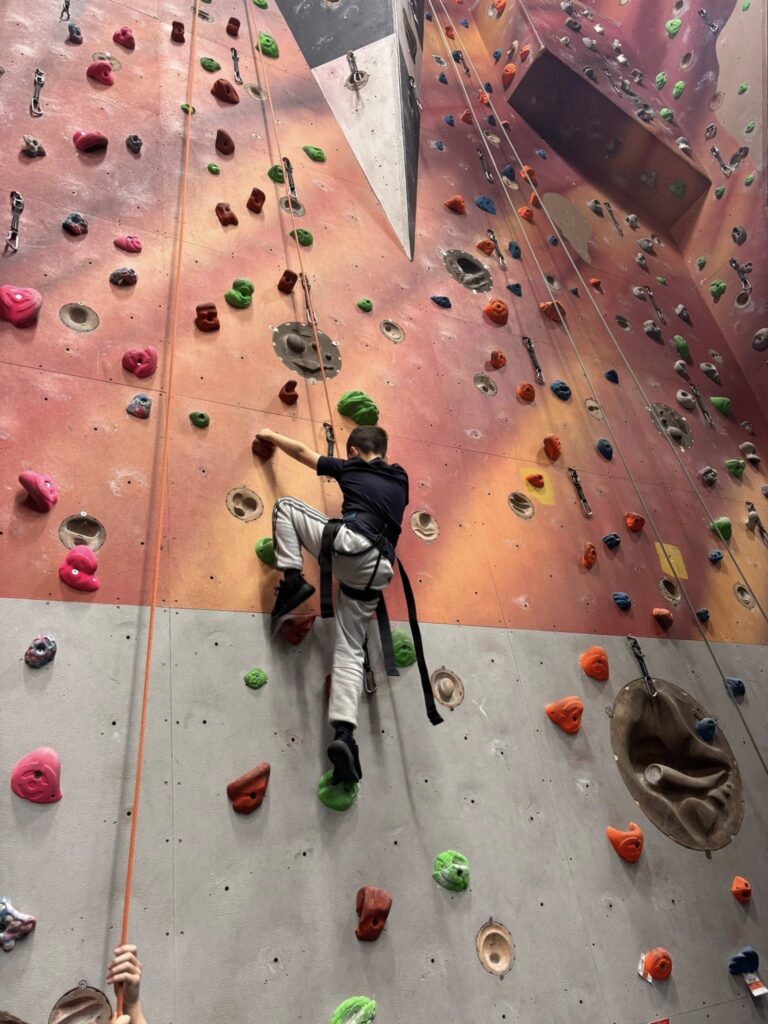 Boy rock climbing indoors