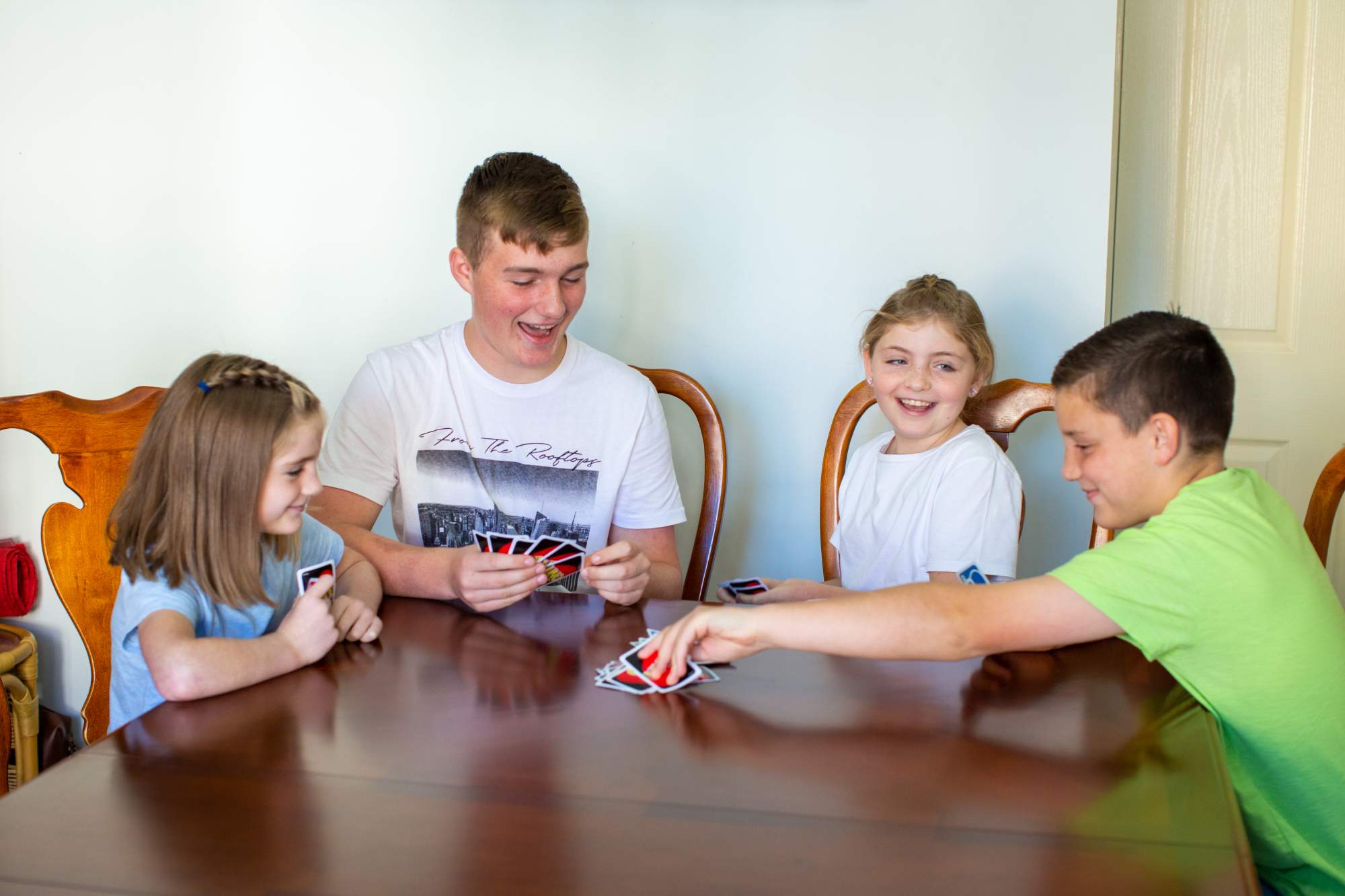 Four siblings have fun playing Uno together