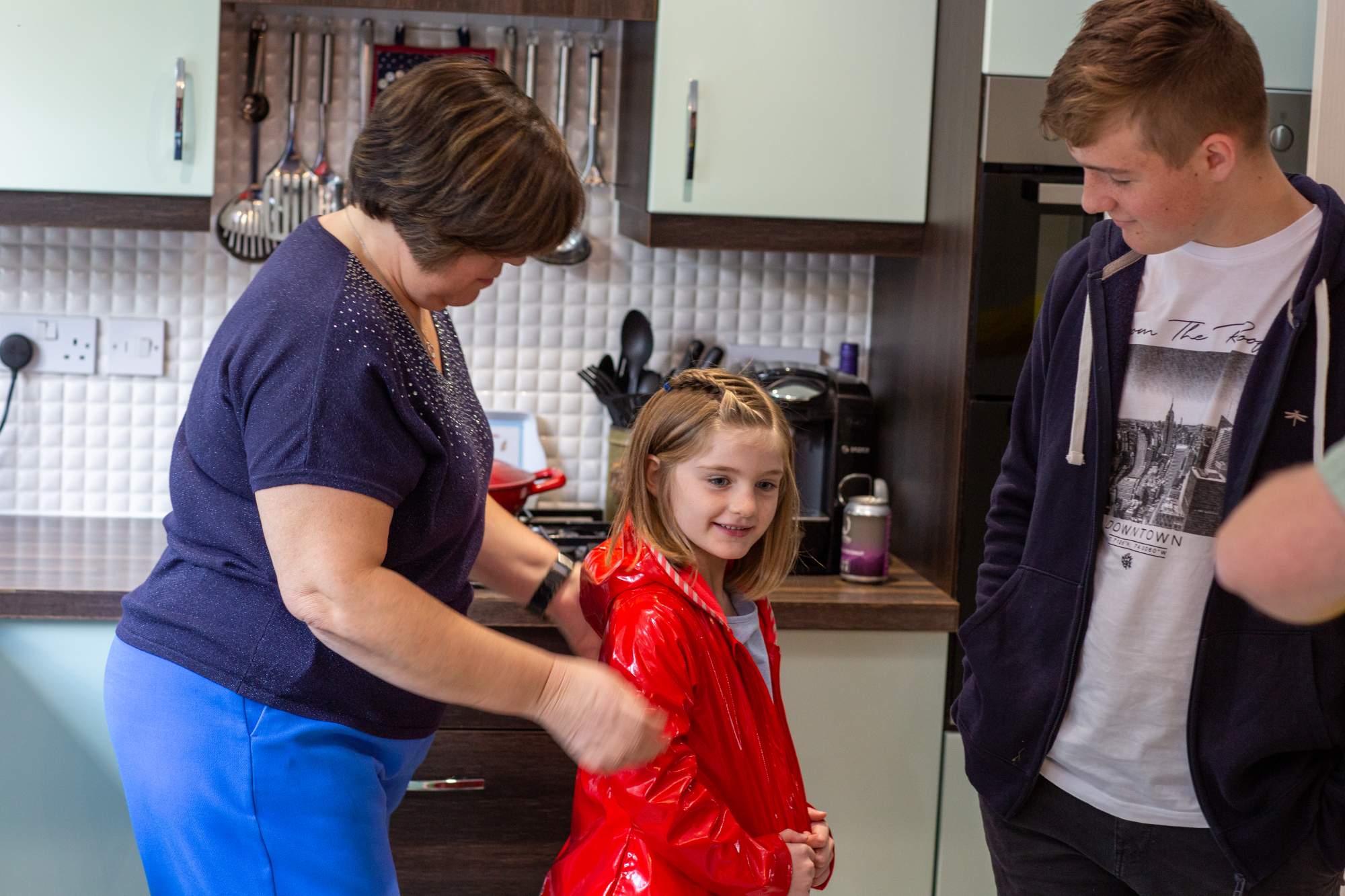 Mum and two children preparing to go outside