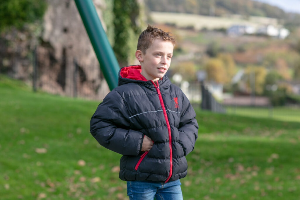 A young boy in a winter coat in the park
